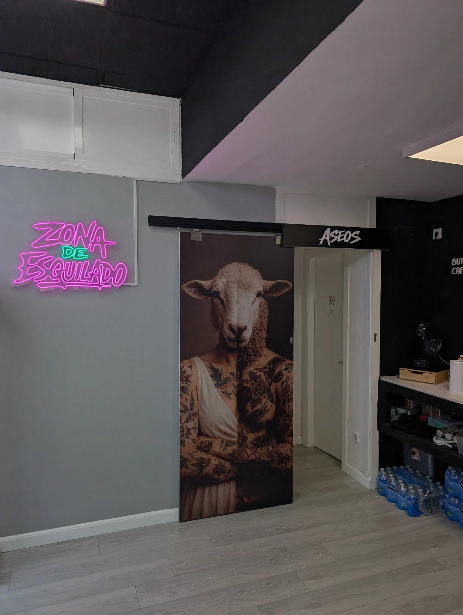 Acceso a aseos y zona de espera con gráfica interior del estudio.